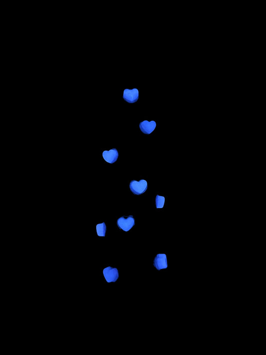 3D-printed phone holder in cosmic blue with pink heart studs, side view holding a phone.